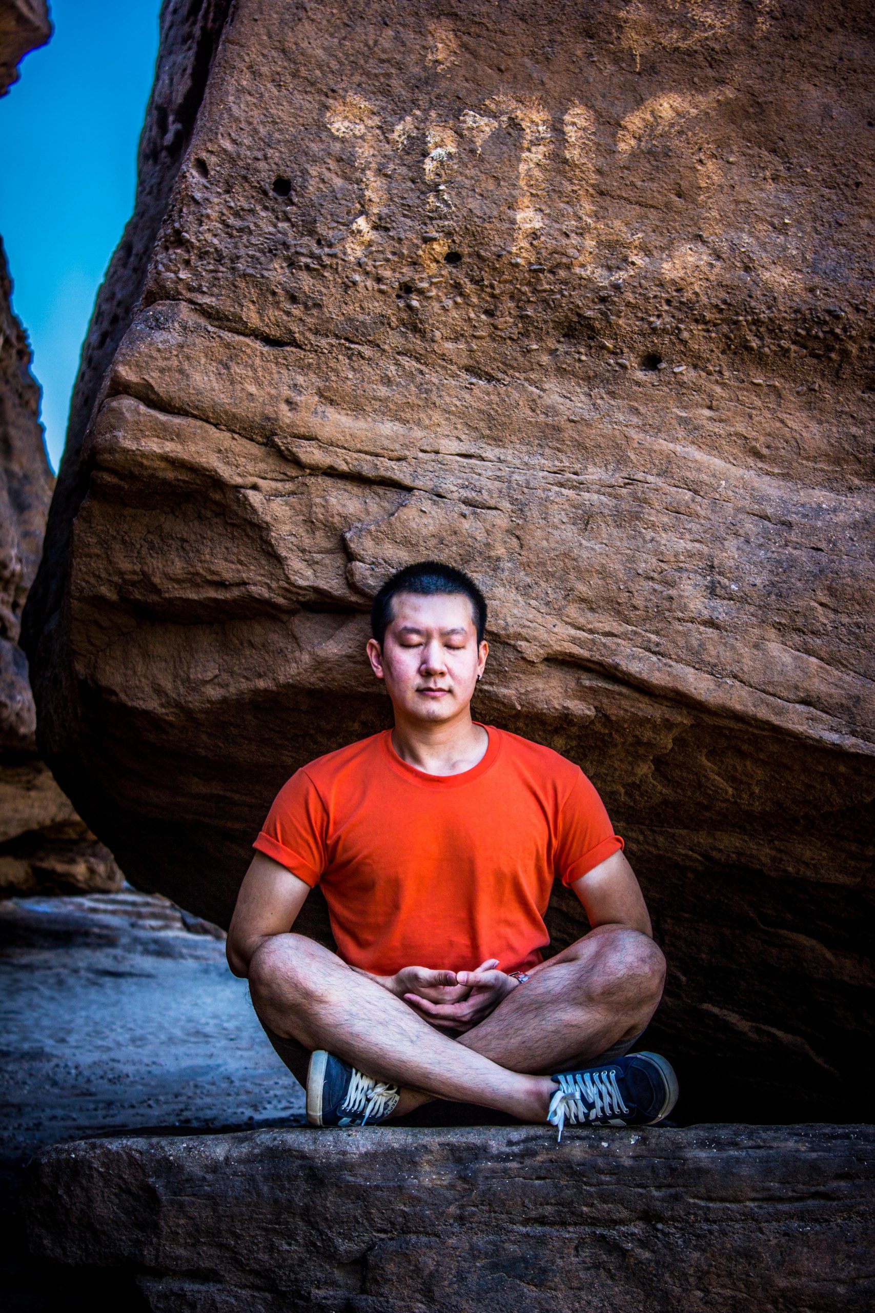 Man meditating near rock